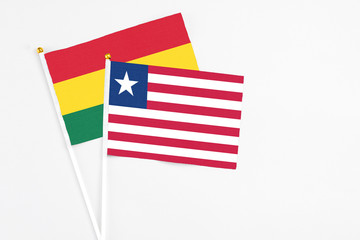 Liberia and Ghana stick flags on white background. High quality fabric, miniature national flag. Peaceful global concept.White floor for copy space.