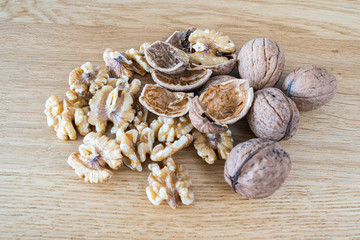 Walnuts on a natural oak wooden background. A natural perspective composition in brown and gold  colors.