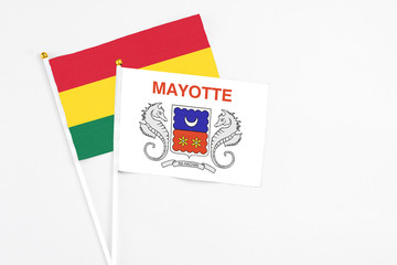 Mayotte and Ghana stick flags on white background. High quality fabric, miniature national flag. Peaceful global concept.White floor for copy space.