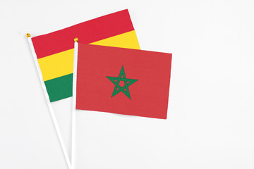 Morocco and Ghana stick flags on white background. High quality fabric, miniature national flag. Peaceful global concept.White floor for copy space.