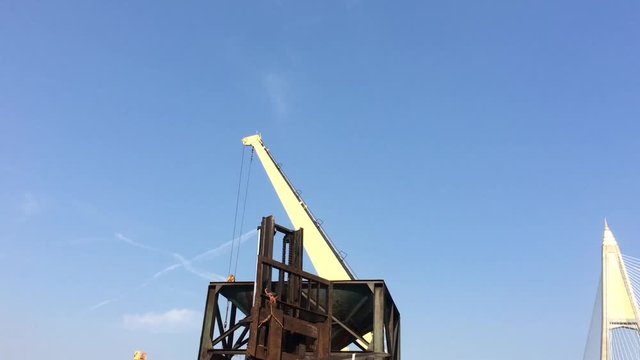 Large yellow scoop Are scooping the white Urea chemical fertilizer From a pontoon boat to unload