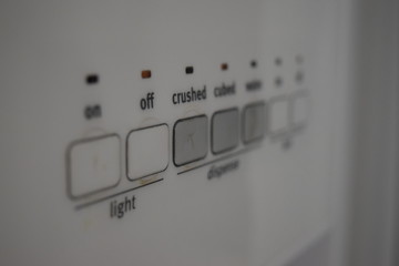 Close up of buttons on a freezer. Kitchen appliances controls. Ice cubes, crushed ice and water dispenser