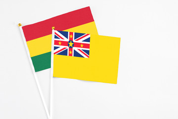Niue and Ghana stick flags on white background. High quality fabric, miniature national flag. Peaceful global concept.White floor for copy space.