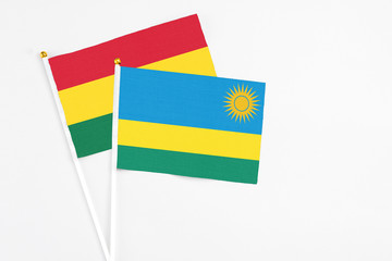 Rwanda and Ghana stick flags on white background. High quality fabric, miniature national flag. Peaceful global concept.White floor for copy space.