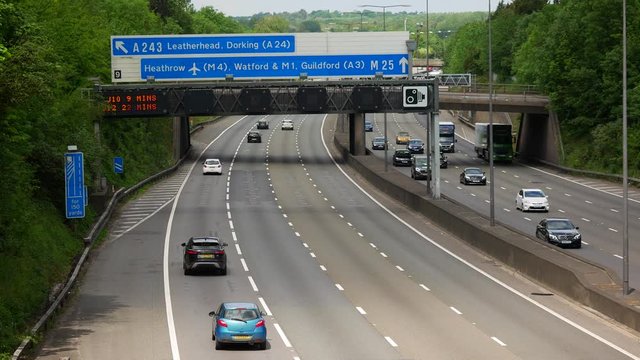 Moderate Traffic under Heathrow road sign on the famous M25 Motorway / London