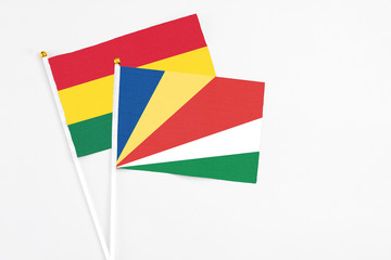 Seychelles and Ghana stick flags on white background. High quality fabric, miniature national flag. Peaceful global concept.White floor for copy space.