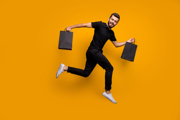 Full body profile photo of handsome guy jumping high running shopping store buying clothes hold...