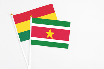 Suriname and Ghana stick flags on white background. High quality fabric, miniature national flag. Peaceful global concept.White floor for copy space.