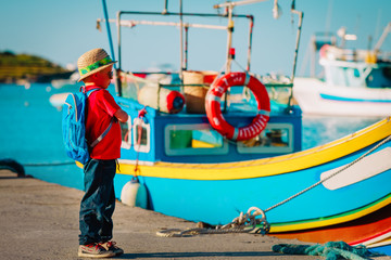 little boy looking at traditional boats in Malta