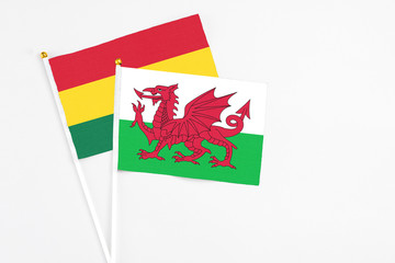 Wales and Ghana stick flags on white background. High quality fabric, miniature national flag. Peaceful global concept.White floor for copy space.
