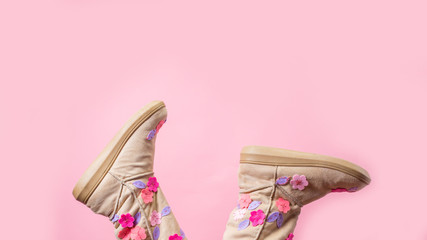 Funny winter female legs boots over pastel background