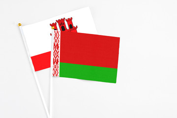 Belarus and Gibraltar stick flags on white background. High quality fabric, miniature national flag. Peaceful global concept.White floor for copy space.