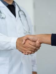 Close up of a doctor shake hands with the patient.