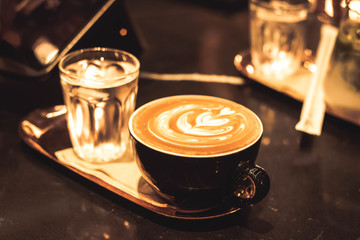 Close up of hot latte coffee in the cafe with blurred background.