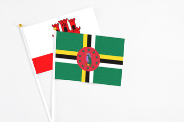 Dominica and Gibraltar stick flags on white background. High quality fabric, miniature national...