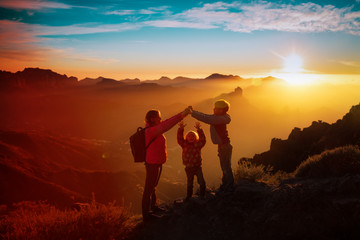 mother with kids -son and daughter - enjoy travel in sunset mountains