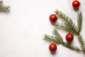 Christmas background. Christmas red balls with Christmas tree branches top view on a light background.
