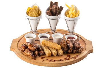 assorted beer snacks like chicken wings, mozzarella sticks, croutons, nachos, french fries isolated on white background