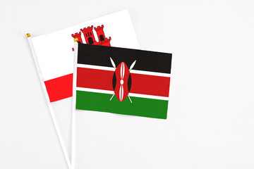 Kenya and Gibraltar stick flags on white background. High quality fabric, miniature national flag. Peaceful global concept.White floor for copy space.