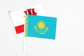 Kazakhstan and Gibraltar stick flags on white background. High quality fabric, miniature national flag. Peaceful global concept.White floor for copy space.