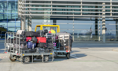 Fototapeta premium Carriage of a lot of luggage of passengers at the airport. airport luggage car