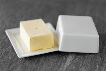 food and dairy products concept - close up of butter on stone table