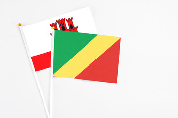 Republic Of The Congo and Gibraltar stick flags on white background. High quality fabric, miniature national flag. Peaceful global concept.White floor for copy space.