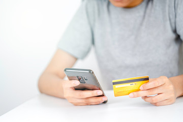 Finance Technology concept, Hand holding yellow credit card and mobile phone