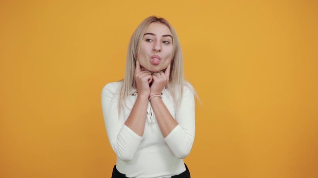 Young funny beautiful caucasian woman wearing nice white shirt puffing cheeks with funny face. Mouth inflated with air, crazy expression.