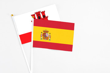Spain and Gibraltar stick flags on white background. High quality fabric, miniature national flag. Peaceful global concept.White floor for copy space.