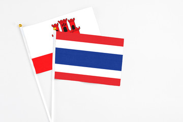 Thailand and Gibraltar stick flags on white background. High quality fabric, miniature national flag. Peaceful global concept.White floor for copy space.