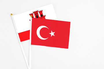 Turkey and Gibraltar stick flags on white background. High quality fabric, miniature national flag. Peaceful global concept.White floor for copy space.