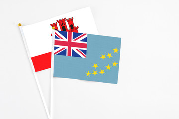Tuvalu and Gibraltar stick flags on white background. High quality fabric, miniature national flag....