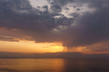 Fototapeta na wymiar beautiful sunset over the sea with rain showers