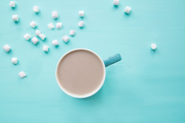 A cup of delicious cocoa with marshmallow on turquoise background, space for text, copy space. 