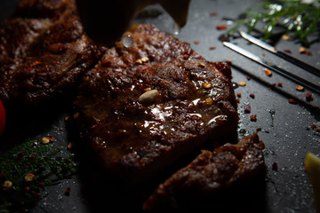  Sliced ​​ Piglet steak. Succulent meat of piglet on black marble background.