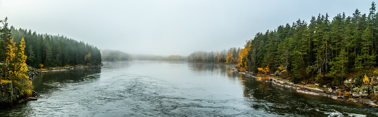 Obraz premium Beautiful autumn landscape of Kymijoki river waters in fog. Panoramic view. Finland, Kymenlaakso, Kotka.