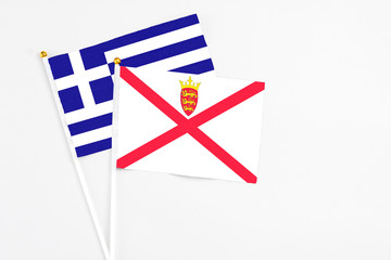 Jersey and Greece stick flags on white background. High quality fabric, miniature national flag. Peaceful global concept.White floor for copy space.