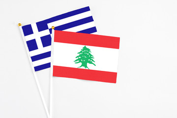 Lebanon and Greece stick flags on white background. High quality fabric, miniature national flag. Peaceful global concept.White floor for copy space.