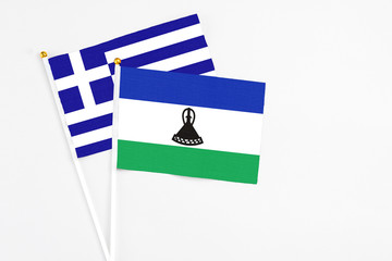 Lesotho and Greece stick flags on white background. High quality fabric, miniature national flag....