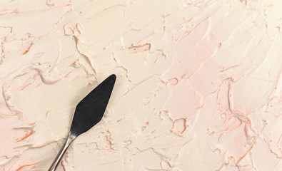 a painting palette knife isolated on a cream painted background painting with copy space.