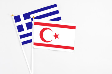 Northern Cyprus and Greece stick flags on white background. High quality fabric, miniature national flag. Peaceful global concept.White floor for copy space.