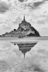 Gruppe steht in der Ferne vor dem Mont St. Michel in der Normandie