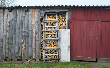 Fototapeta na wymiar A full barn of chopped birch firewood stacked in a barn. Harvesting firewood for the winter.