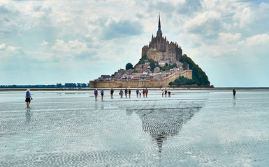 Gruppe mit Kindern wattwandert mit Guide zum Mont St. Michel