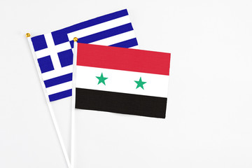 Syria and Greece stick flags on white background. High quality fabric, miniature national flag. Peaceful global concept.White floor for copy space.