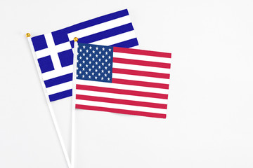 United States and Greece stick flags on white background. High quality fabric, miniature national flag. Peaceful global concept.White floor for copy space.