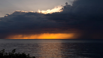 Fototapeta na wymiar Dramatic sunset over water