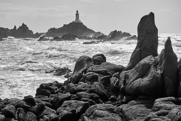 La Corbiere Leuchtturm auf Jersey bei Flut und Sonnenschein mit Wellengang