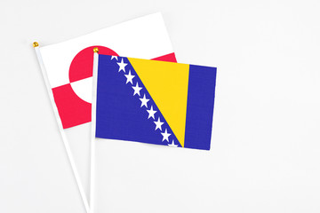 Bosnia Herzegovina and Greenland stick flags on white background. High quality fabric, miniature national flag. Peaceful global concept.White floor for copy space.